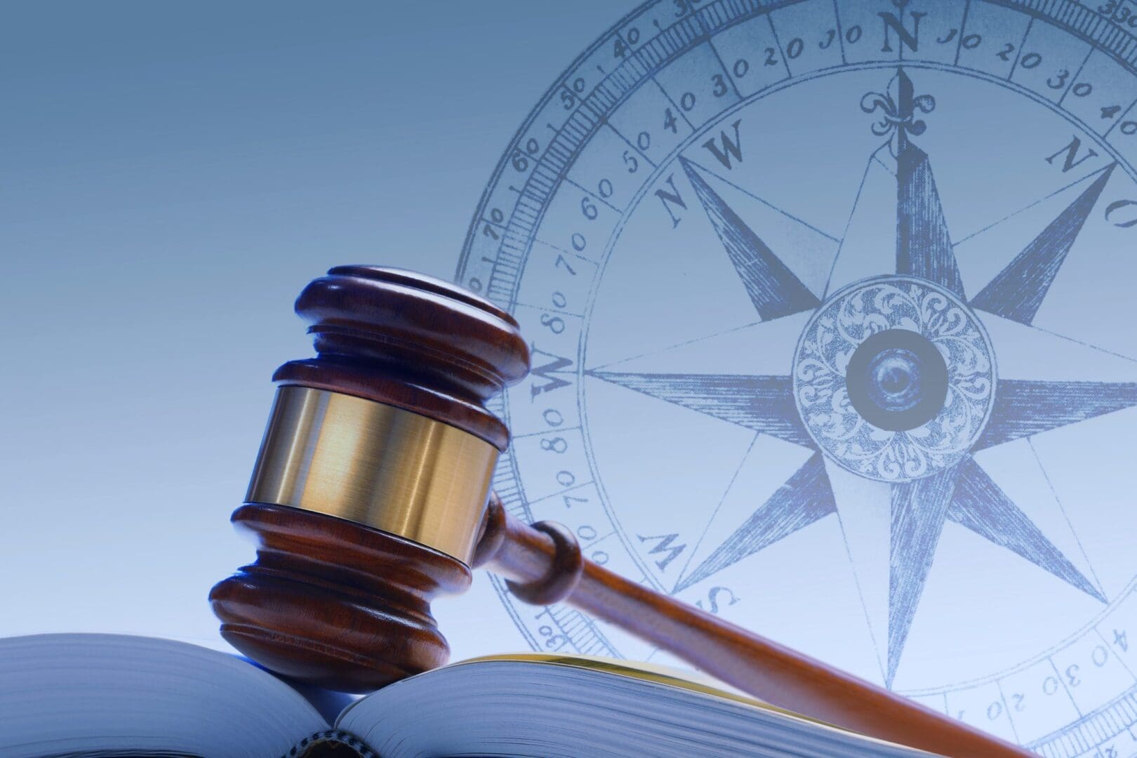 Judge's gavel and compass symbolizing law and direction.