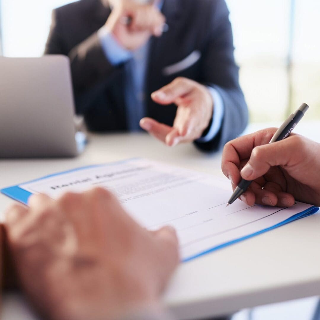 Two professionals discussing and signing a document in an office setting.
